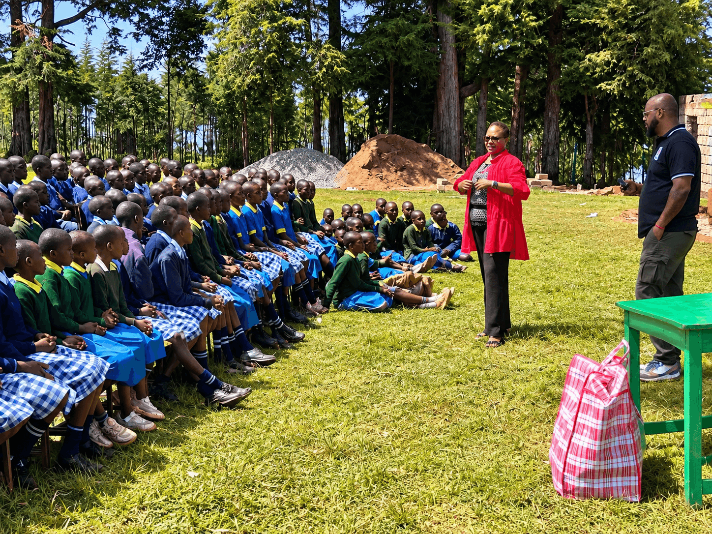 Prof. Rotich addressing rows of primary-school students gathered in a sunlit school courtyard in Kenya